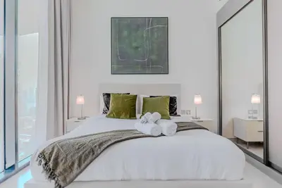 a bedroom with a large white bed with two towels at TRPS - Binghatti Royale, JVC - Private Pool, Luxury Furnished, Brand New in Dubai
