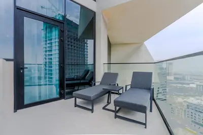 two chairs and a table in a room with windows at TRPS - Binghatti Royale, JVC - Private Pool, Luxury Furnished, Brand New in Dubai