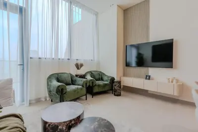 a living room with two chairs and a flat screen tv at TRPS - Binghatti Royale, JVC - Private Pool, Luxury Furnished, Brand New in Dubai
