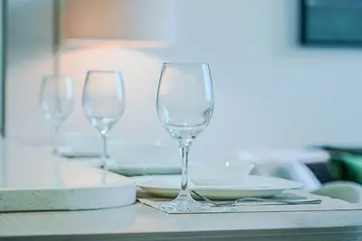 three empty wine glasses sitting on a table at TRPS - Binghatti Royale, JVC - Private Pool, Luxury Furnished, Brand New in Dubai