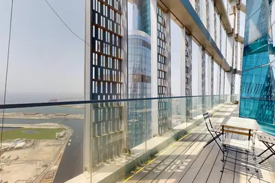a balcony in a tall building with chairs and a table at Vacationer l Magnificent 4 Bedroom l Penthouse l Marina Views in Dubai