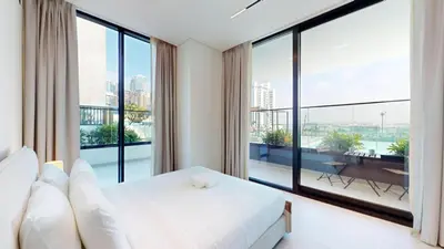 a bedroom with a white bed and large windows at Vacationer l 1 Bedroom in Business Bay l Direct Pool Access in Dubai