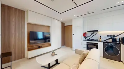 a living room with a white couch and a kitchen at Vacationer l 1 Bedroom in Business Bay l Direct Pool Access in Dubai