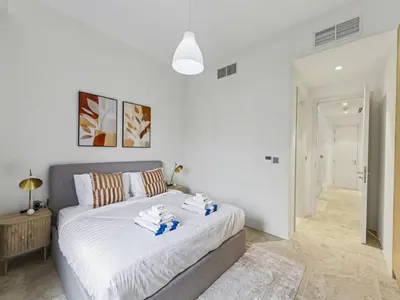 a bedroom with a bed with towels on it at Redwood Townhouse Jumeirah Golf Estates in Dubai