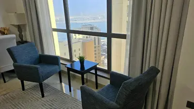 a room with two chairs and a table in front of a window at Beach, Palm Jumeirah & Marina view in Dubai