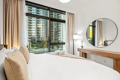 a bedroom with a white bed and a large window at FIRST CLASS 1BR Creek Escape & Modern Elegance in Dubai