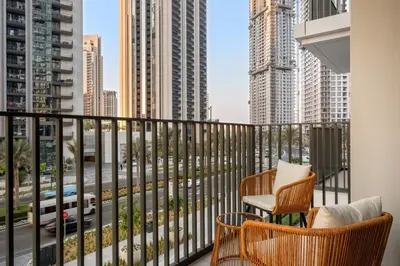 a balcony with two chairs and a view of a city at FIRST CLASS 1BR Creek Escape & Modern Elegance in Dubai