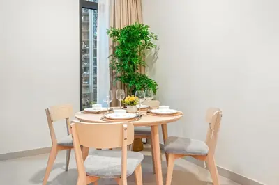 a dining room table with chairs and a plant at FIRST CLASS 1BR Creek Escape & Modern Elegance in Dubai