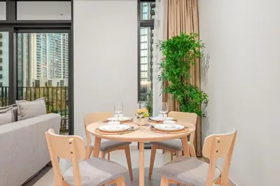a dining room with a table and chairs and a couch at FIRST CLASS 1BR Creek Escape & Modern Elegance in Dubai
