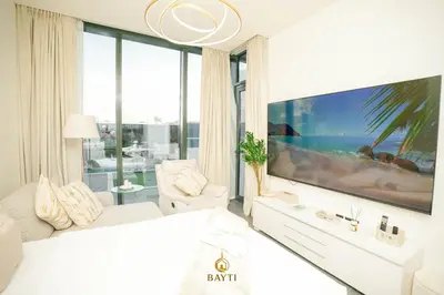 a white bedroom with a large tv and a bed at Evasion de luxe avec vue piscine, billard et lounge, à 15 minutes burj khalifa in Dubai