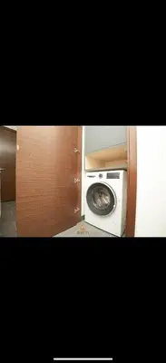 a kitchen with a washing machine in a cabinet at Evasion de luxe avec vue piscine, billard et lounge, à 15 minutes burj khalifa in Dubai