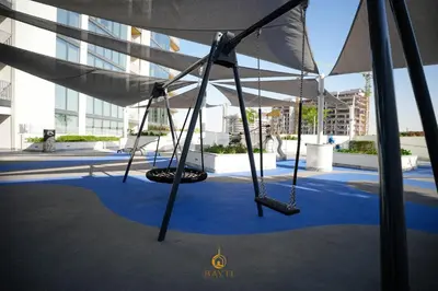 a swing set on a blue carpet in a building at Evasion de luxe avec vue piscine, billard et lounge, à 15 minutes burj khalifa in Dubai