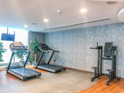a gym with three tread machines in a room at GuestReady - 1BR | Elegant Duplex | JLT in Dubai