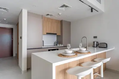 a kitchen with a large white island with stools at GuestReady - 1BR | Elegant Duplex | JLT in Dubai