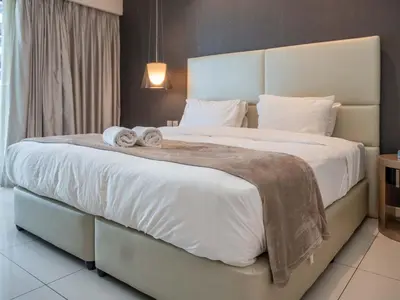 a bedroom with a large bed with towels on it at Paramount Tower - Stylish 2BR Apartment with Balcony & Pool - Near Dubai Mall in Dubai
