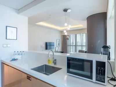 a kitchen with a sink and a microwave at Paramount Tower - Stylish 2BR Apartment with Balcony & Pool - Near Dubai Mall in Dubai