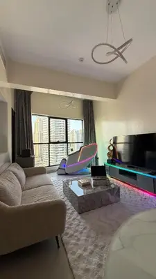 a large living room with a couch and a tv at Futuristic luxury apartment, 360 lake view balcony in Dubai
