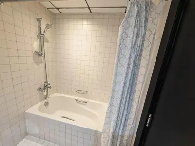a bath tub with a shower curtain in a bathroom at 1 Bedroom in Dubai Marina Walk, Partial Water View in Dubai