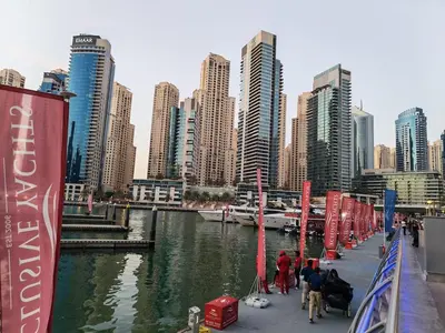 a group of people standing on a dock next to a river at 1 Bedroom in Dubai Marina Walk, Partial Water View in Dubai