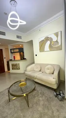 a living room with a couch and a glass table at Luxury 1BR Apt with water canal & Marina View in Dubai