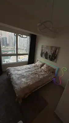 a bedroom with a bed with a large window at Luxury 1BR Apt with water canal & Marina View in Dubai