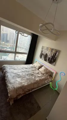 a bed in a bedroom with a large window at Luxury 1BR Apt with water canal & Marina View in Dubai