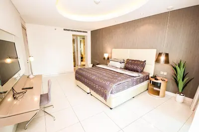 a bedroom with a bed and a desk and a television at Newly Furnished Luxury 1BHK at Paramount Tower D in Dubai