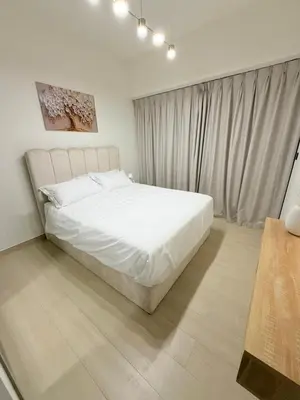 a bedroom with a white bed and a window at Luxury Binghatti Crest 1BR Apartment with Pool & Balconies in Dubai
