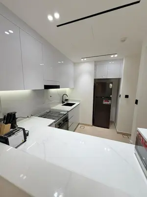 a kitchen with white cabinets and a black refrigerator at Luxury Binghatti Crest 1BR Apartment with Pool & Balconies in Dubai