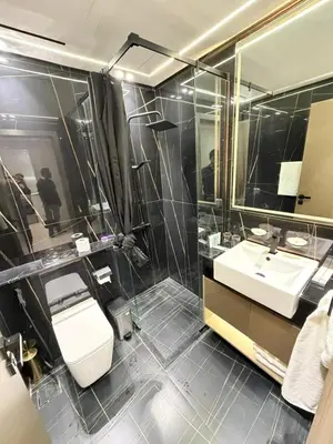 a bathroom with a toilet and a sink and a mirror at Luxury Binghatti Crest 1BR Apartment with Pool & Balconies in Dubai