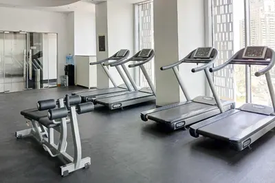 a row of treadmills in a gym at PVH - Refined 1BR in Marina - Cayan Tower in Dubai