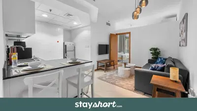 a kitchen and a living room with a counter top at StayShort - 1 Bed Apartment Sleeps 4 in Dubai Marina in Dubai