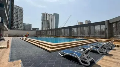 a swimming pool with lounge chairs on the roof of a building at Chic studio located in the heart of Business Bay in Dubai