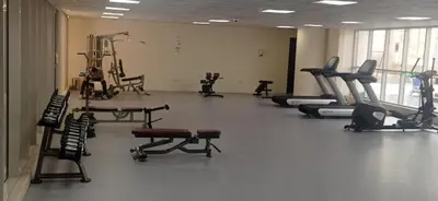 a gym with several treadmills and exercising machines at Chic studio located in the heart of Business Bay in Dubai