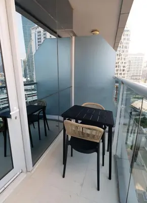 a black table and chairs on a balcony at Chic studio located in the heart of Business Bay in Dubai