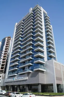 a large building with cars parked in front of it at Chic studio located in the heart of Business Bay in Dubai