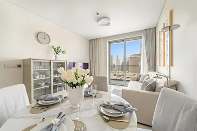 a dining room with a table with flowers on it at Premium 2BR Burj Khalifa View at Vida Dubai Mall in Dubai