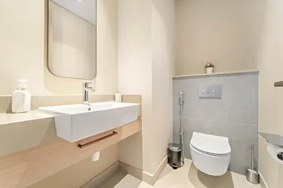 a bathroom with a white sink and a toilet at Premium 2BR Burj Khalifa View at Vida Dubai Mall in Dubai