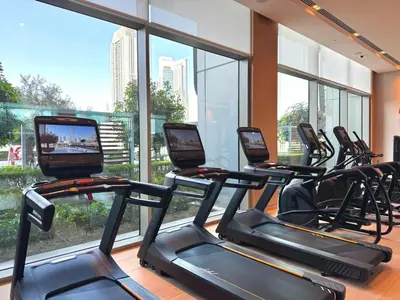 a row of treadmills in a gym with large windows at Premium 2BR Burj Khalifa View at Vida Dubai Mall in Dubai