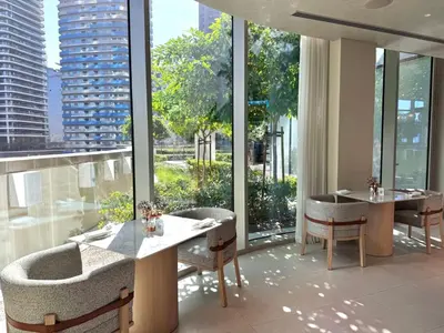 a restaurant with tables and chairs and large windows at Premium 2BR Burj Khalifa View at Vida Dubai Mall in Dubai