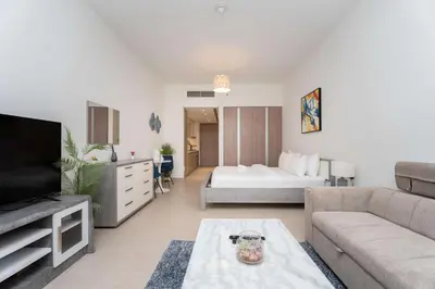 a living room with a couch and a bed at Modern Marina Studio w City Views & King Bed in Dubai