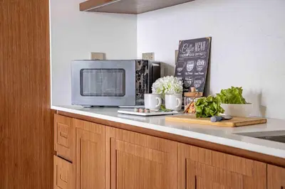 a kitchen with a microwave on a counter with vegetables at Frank Porter - Palace Beach Residence in Dubai