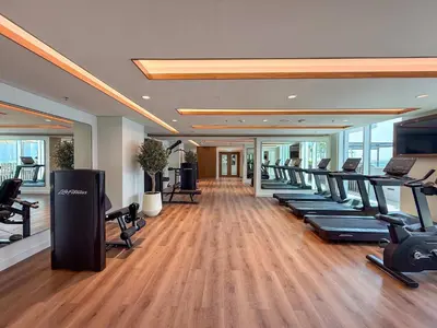 a gym with a row of treadmills and exercise bikes at Frank Porter - Palace Beach Residence in Dubai