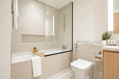 a bathroom with a tub and a toilet and a sink at Frank Porter - Island Park 2 in Dubai
