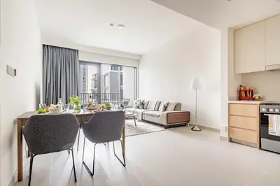 a kitchen and living room with a table and chairs at Frank Porter - Island Park 2 in Dubai