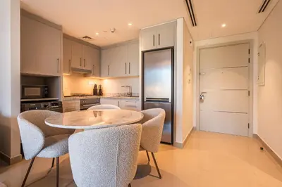 a kitchen with a table and chairs in a room at Burj khalifa view I Sofa bed I walking distance to Dubai Mall in Dubai