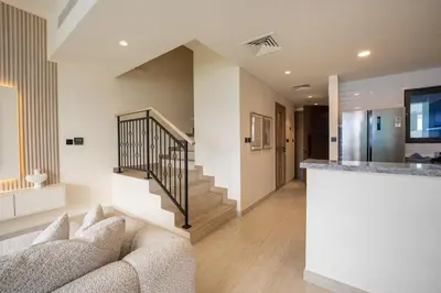 a living room with a couch and a staircase at Santorini Damac Lagoons Luxury 3BR Villa Mediterrean Bliss in Dubai