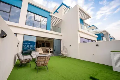 a house with a green lawn in front of it at Santorini Damac Lagoons Luxury 3BR Villa Mediterrean Bliss in Dubai
