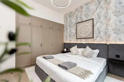 a bedroom with a large bed with white sheets and pillows at Santorini Damac Lagoons Luxury 3BR Villa Mediterrean Bliss in Dubai