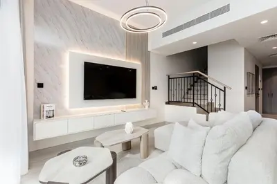 a living room with a white couch and a tv at Santorini Damac Lagoons Luxury 3BR Villa Mediterrean Bliss in Dubai